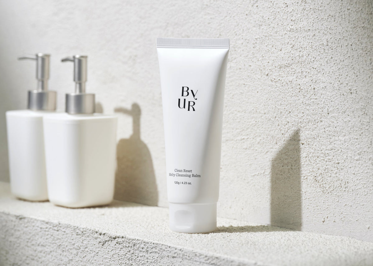 White skincare products on a textured surface with a neutral background
